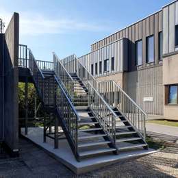 Bemalte Metalltreppen für den Zugang zum Gebäude, aus Aluminium.