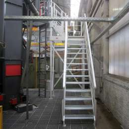 Aluminium stairs for machine access and maintenance in a factory.