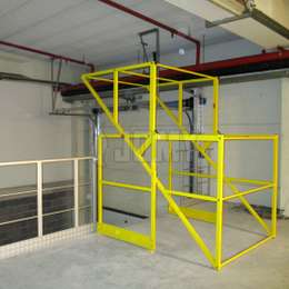 Mezzanine équipée d'une barrière écluse basculante en aluminium peint en jaune.