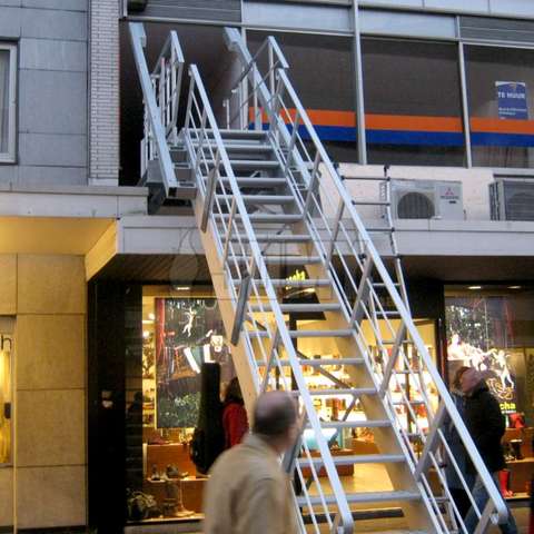 Evacuation stairs sliding out of the facade of a building before pivoting smoothly to the ground.