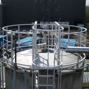 Curved guardrail on top of a tank.