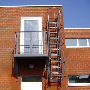 RAL colored drop-down ladder for fire evacuation with access balcony.