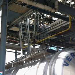 Ship ladder that drops down from a platform and on top of tanker truck trailers.