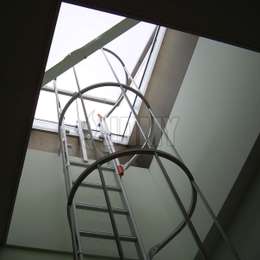 Echelle à crinoline utilisée dans un puits de lumière pour l'accès à la toiture plate depuis une fenêtre de toit.