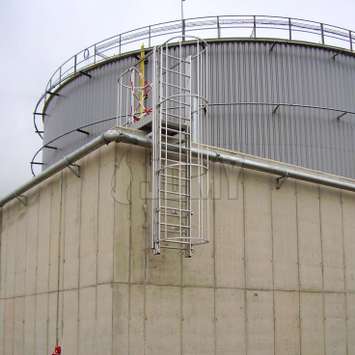 Echelle coulissante de sécurité utilisée pour franchir un mur de protection dans une raffinerie de pétrole.