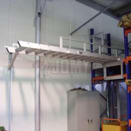 Echelle de meunier escamotable/relevable utilisée pour accéder à une mezzanine industrielle de stockage.