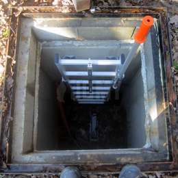 Echelle de puits en aluminium avec poignées télescopiques permettant de descendre dans une fosse.
