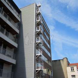 Echelle d'évacuation incendie à crinoline de 7 étages, avec balcons d'accès pour un immeuble de bureaux.