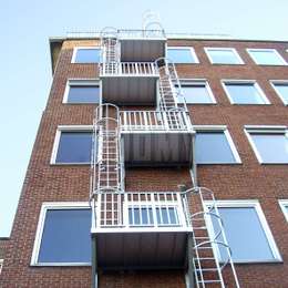 Echelle de secours à crinoline utilisée pour l'évacuation d'un immeuble d'appartements de hauteur moyenne.