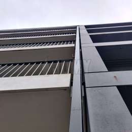 Echelle déployable intégrée au bâtiment et peinte pour une voie d'évacuation furtive depuis les balcons d'appartements.