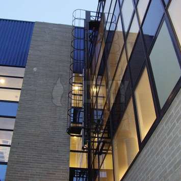 Escalera con jaula para limpieza de ventanas y acceso a fachadas - Unidad de mantenimiento de edificios