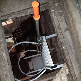 Escalera de acceso con jaula para la boca de acceso al campanario de una iglesia Escalera de acceso en una iglesia, con barandilla telescópica, en el campanario y utilizada para el mantenimiento de las campanas.