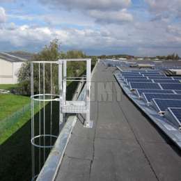 Escalera de techo con jaula utilizada para acceso y mantenimiento de paneles solares.