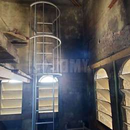 Escalera de acceso lateral con jaula en el campanario de una iglesia Escalera con acceso lateral y jaula para subir a una plataforma en el campanario de una iglesia