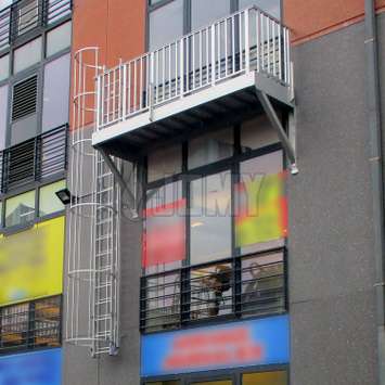 Escalera con jaula y balcón para la evacuación de seguridad en un edificio de oficinas.