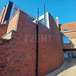 2 escaleras retráctiles para la evacuación de incendios desde techos en diferentes niveles de una vivienda, y asegurada a la calle.