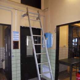 Escalera de gancho removible para acceso técnico La escalera de gancho solía acceder a una puerta de servicio situada encima de una puerta de pasillo.