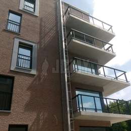 Escalera retráctil de 4 pisos para escape de incendios en posición abierta para una edificación residencial.