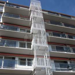 Escalera de incendios de 5 pisos con jaula y estructura decorativa en aluminio para egreso desde los balcones de un edificio de apartamentos.