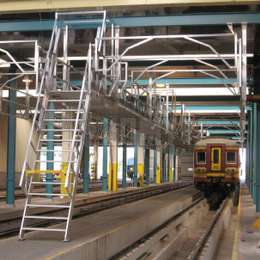 Pasarela y escalera de barco que se utiliza para acceder a los tejados de los trenes con fines de mantenimiento en un taller.