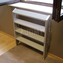 Escalera de aluminio que se puede plegar hacia la pared para ahorrar espacio. Usada debajo de una ventana para egreso.