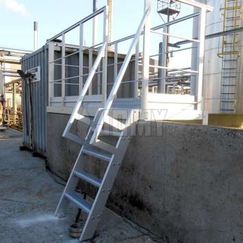 Escalera de tijera para acceso y plataforma de trabajo sobre una pared exterior.