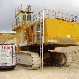 Excavadora de servicio pesado con escalera abatible para acceder a la cabina.