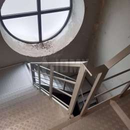 Escalera metálica con giro de 90° - Campanario de una iglesia Escalera metálica con giro de 90° ubicada en la base de un campanario, sujeta a la pared con soportes.