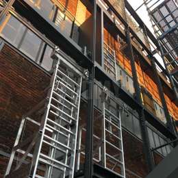 Escalera y pórtico para el mantenimiento detrás de estructuras arquitectónicas para protección solar.