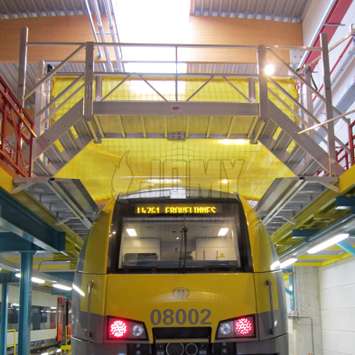 Escaleras de cruce auto sostenibles utilizadas como puente en una instalación de mantenimiento de trenes.