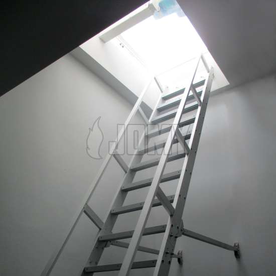 Escalera contrabalanceada de mano, fabricada en aluminio, usada para acceder a un entresuelo industrial.