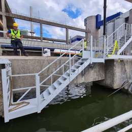 Escaleras de acceso y rellano justo encima del agua, utilizadas para acceder a barcazas para transporte fluvial.