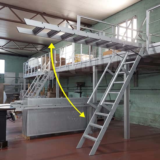 Escalier équilibré relevable en aluminium montée sur vérins à gaz et permettant d'accéder à une mezzanine industrielle.