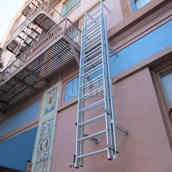 Fire escape drop-down ladder with cage used to link a balcony to the ground floor for the evacuation of a public building.