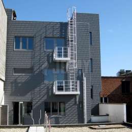 Roof fire escape route made of a cage ladder, balconies and a securable retractable ladder at the bottom for an office building.