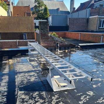 Fire escape ladder resting on a flat roof.