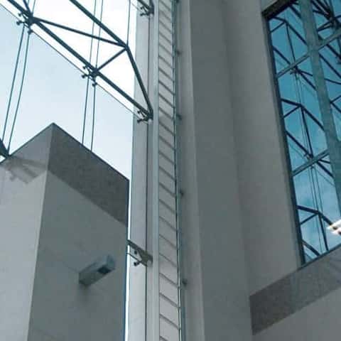 Mini-Jomy uitklapbare ladder in geopende toestand gemonteerd in een gebouw als onderhoudsladder met een levenslijn