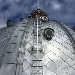 Gebogenes Rettungsleinensystem für eine Leiter auf einer Kirchendachkuppel.