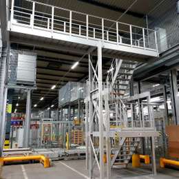 Two-level industrial stairs and walkway platform used in a warehouse for access purposes.