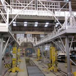 Durchfahrbare Industrieplattform für den Zugang zu Wagendächern in einer Eisenbahnwerkstatt.
