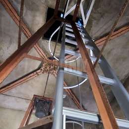 Cage ladder for access to a manhole in a church steeple and installed away from the wall with special fixing brackets.