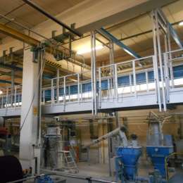 Plataforma y pasarela de aluminio suspendidas usadas en el interior de una fábrica.