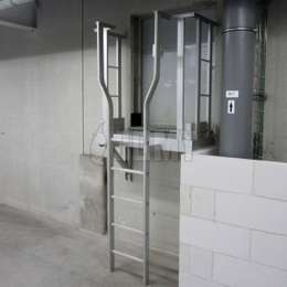 Escalera fija industrial y plataforma de acceso para el cuarto de mantenimiento de una fábrica.