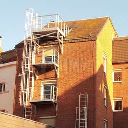 Plataforma para escape de incendios y escalera con jaula en la parte trasera de un edificio de apartamentos. 