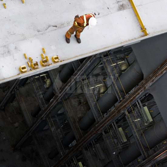 Ouvrier industriel debout au bord du gouffre, sans protection.