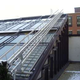 Sliding shipladder for angled glass roof cleaning.