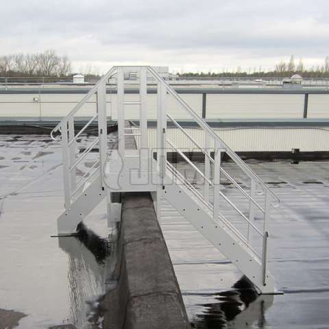 Step-over stairs on a building roof used to bridge two levels and a wall.