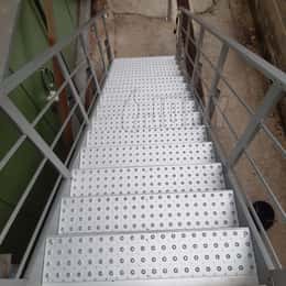 Extruded step profiles with anti-slip tread plates with perforations and standing edges.