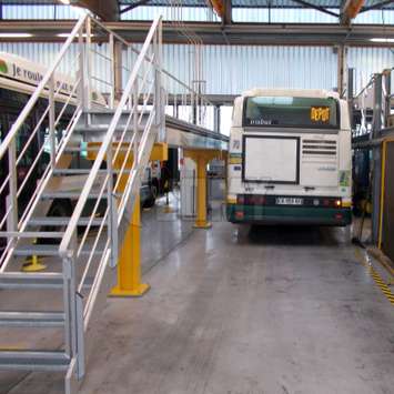 Industrielle Aluminiumtreppen und Plattform für Buswartung in einer Reparaturwerkstatt / einer Garage.