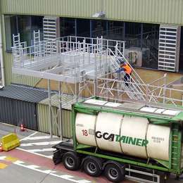 Truck access platform with drop-down ladders to access the manholes of the tank trailers to work safely.